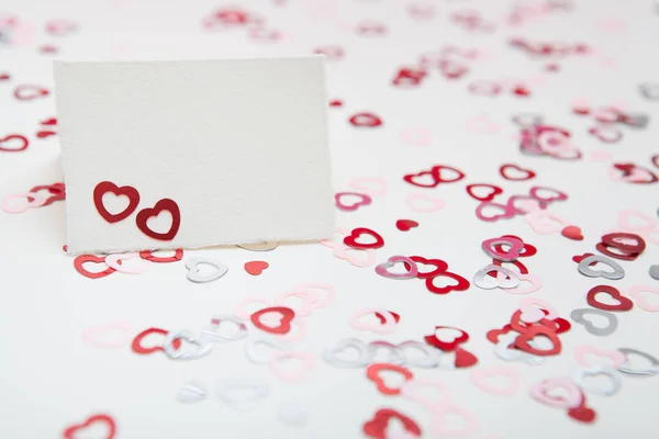 Ευχετήρια κάρτα σε λευκό φόντο με πολύχρωμες καρδιές κομφετί. Ημέρα του Αγίου Βαλεντίνου έννοια — Φωτογραφία Αρχείου