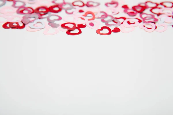 Corazones rojos y rosados confeti sobre fondo blanco. Bonito y sencillo concepto de San Valentín . — Foto de Stock