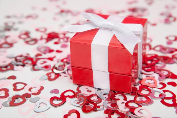 Rode gift box voor sieraden op een witte achtergrond met kleurrijke harten confetti. Valentines wenskaart Rechtenvrije Stockafbeeldingen