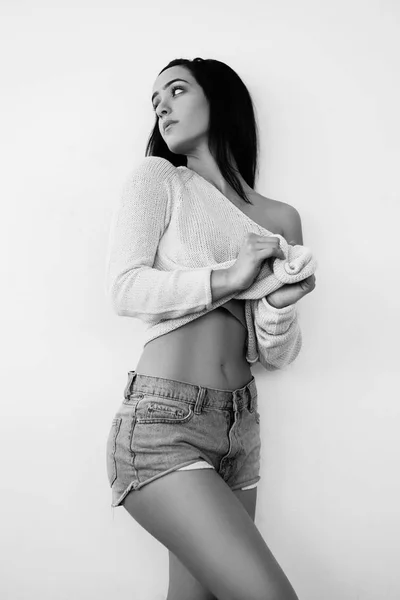 Schöne sexy Frau mit perfektem Körper steht in der Nähe der Wand. Schwarz-Weiß-Foto — Stockfoto
