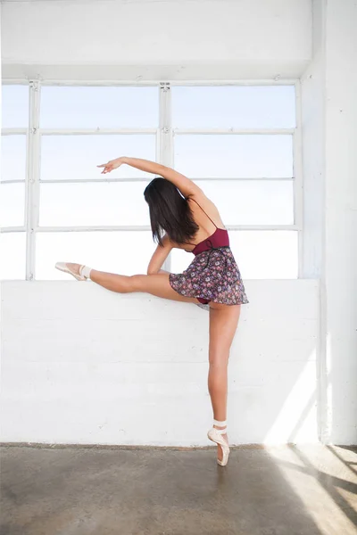 Fiatal táncos nő húzódik magát közelében ablak — Stock Fotó