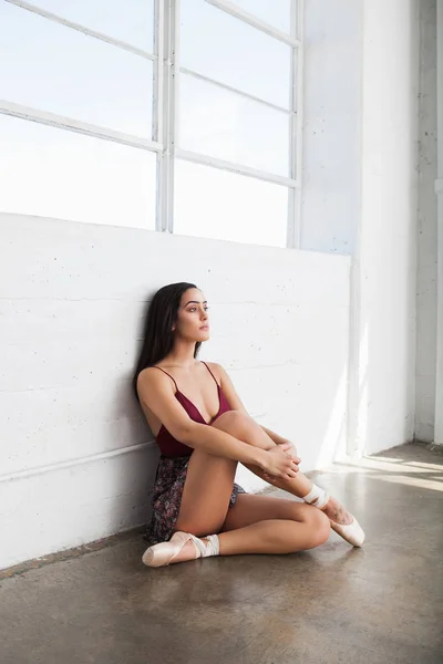 Ballerina is sitting on the floor in a studio — Stock Photo, Image