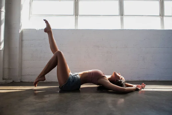 Beautiful sexy woman with perfect body is lying on the floor — Stock Photo, Image