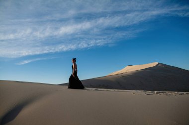 Güzel Asyalı kadın uzun siyah elbise çöl peyzaj