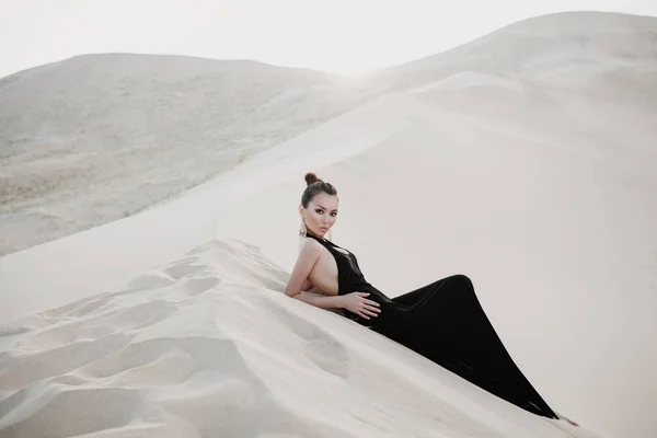 Bella sexy donna asiatica in un abito nero su una duna del deserto — Foto Stock
