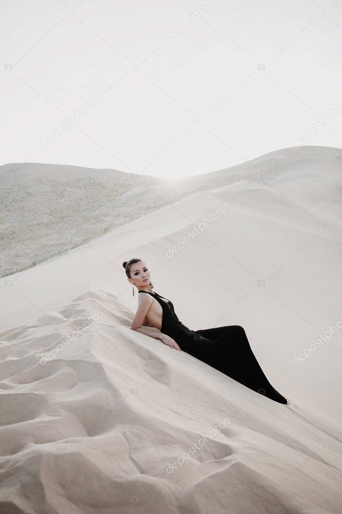 Beautiful sexy asian woman on a dune of desert