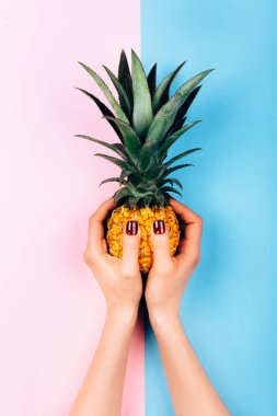 Ananas şık pembe üzerinde elleriyle