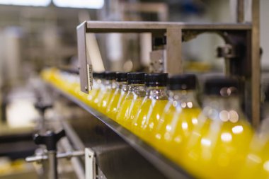 İçerideki sanayi fabrikaları ve makineler. Soda ve portakal suyu şişelerini işlemek ve şişelemek için robot fabrikası hattı.