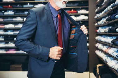 Şık ve modern kıdemli iş adamı pahalı mağazalardan süit seçip alıyor.