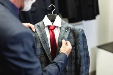 Şık ve modern kıdemli iş adamı pahalı mağazalardan süit seçip alıyor..
