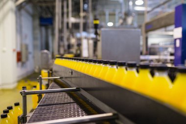 İçerideki sanayi fabrikaları ve makineler. Soda ve portakal suyu şişelerini işlemek ve şişelemek için robot fabrikası hattı.
