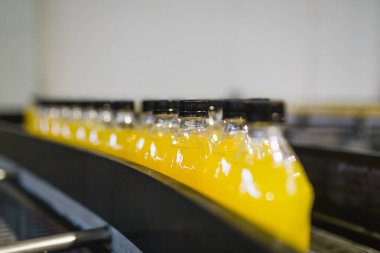 İçerideki sanayi fabrikaları ve makineler. Soda ve portakal suyu şişelerini işlemek ve şişelemek için robot fabrikası hattı.