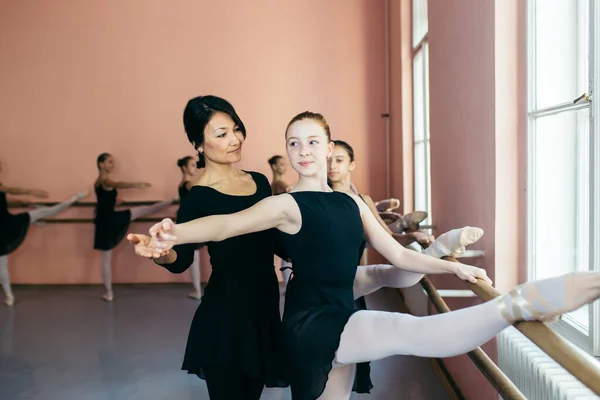 Choreographed dance by a group of beautiful young ballerinas practicing during class at a classical ballet school.