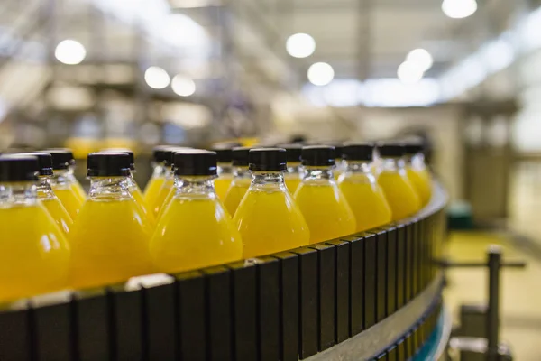 工業工場屋内と機械 ソーダ オレンジジュースボトルの加工 瓶詰め用ロボット工場 — ストック写真
