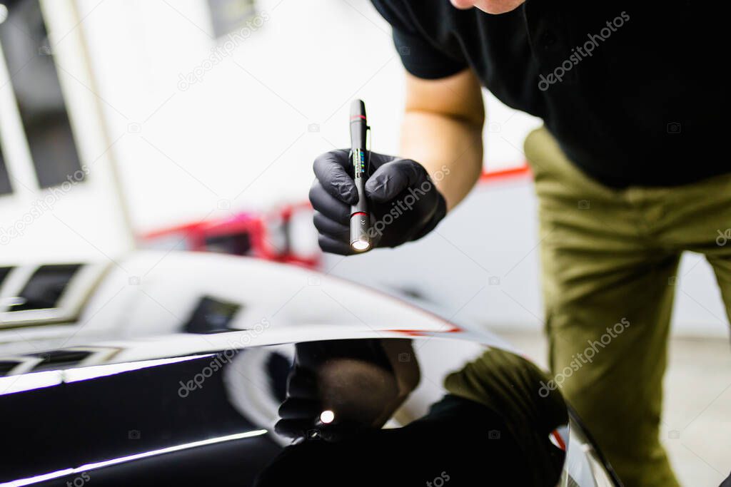 Car detailing, workers with orbital polishers in auto repair shop.  