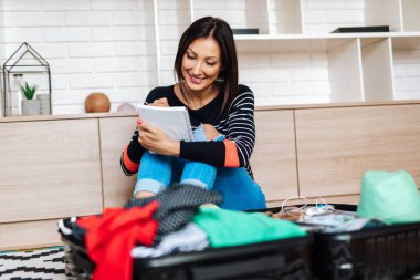 Güzel genç bir kadın eşyalarını büyük bir bavula koyuyor. Seyahat hazırlık konsepti. 