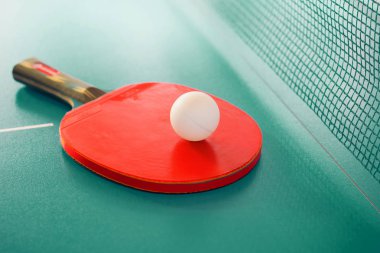 Kırmızı raket ve masa tenisi için bir top.