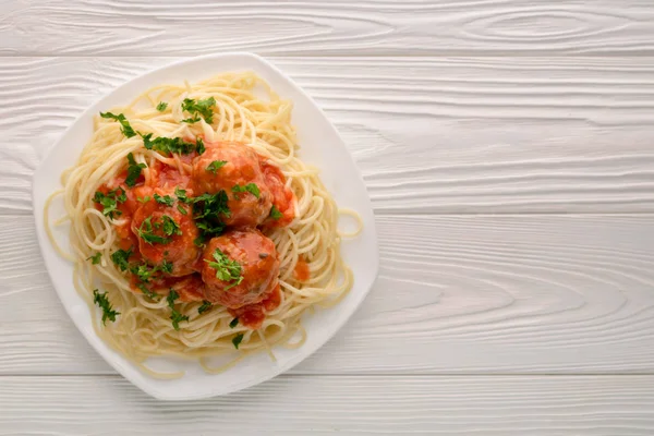 Спагетти с томатным соусом и петрушкой на белом деревянном фоне — стоковое фото