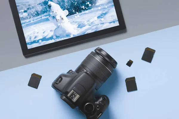 Câmera SLR digital com vista superior e tablet com uma imagem da paisagem de inverno: o conceito de umas férias de inverno ou treinamento em fotografia — Fotografia de Stock