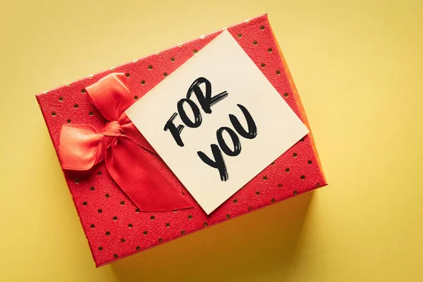 Nahaufnahme einer Geschenkschachtel mit einem Zettel mit der Aufschrift "für Sie" auf gelbem Hintergrund: Ausdruck von Dankbarkeit oder Liebe — Stockfoto