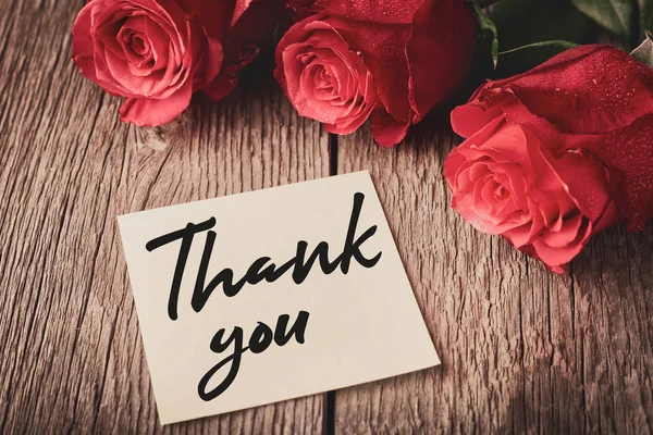Danksagung mit "Danke" -Aufschrift und Blütenknospen roter Rosen auf Holzgrund: das Konzept der Manifestation von Dankbarkeit und Wertschätzung — Stockfoto