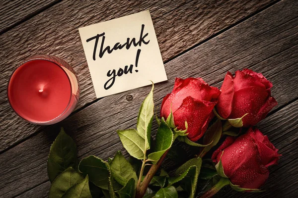 Danksagung und rote Rosen mit Duftkerzen auf einem hölzernen Hintergrund: Konzept eines romantischen Geschenks und Dank — Stockfoto