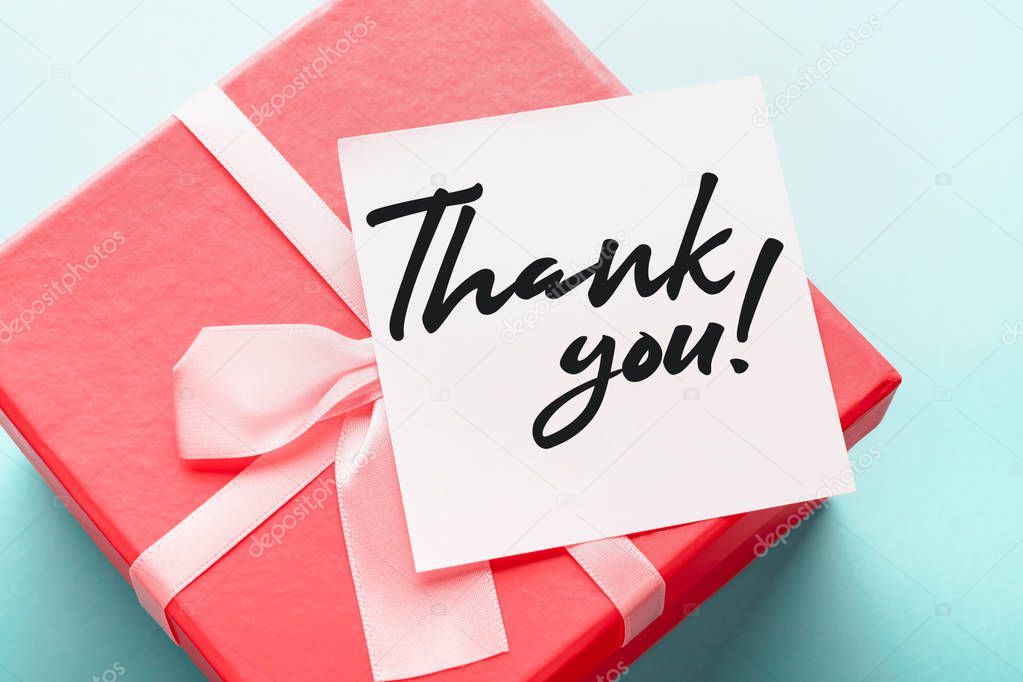 Close up of a red gift box with a note with the words 