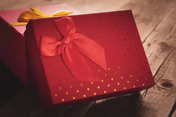 Ahşap arka planda kırmızı hediye kutularının kapatılması: bayram veya romantik hediye kavramı — Stok fotoğraf