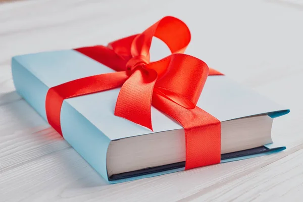 Nahaufnahme eines gebundenen Buches mit Geschenkband: Das Konzept eines guten Buches ist ein gutes Geschenk — Stockfoto