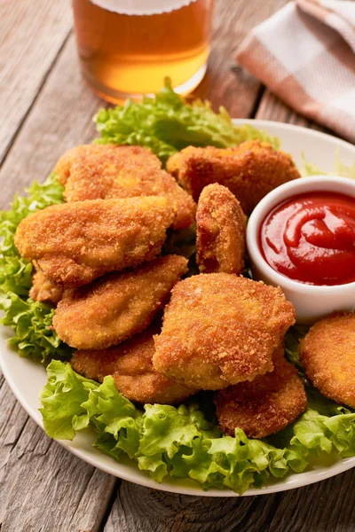 Close up of chicken nuggets with ketchup and lettuce on a wooden background — Stock Photo, Image