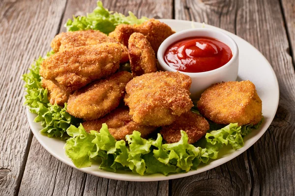 Close up plate with fried chicken nuggets with lettuce and ketchup — 스톡 사진