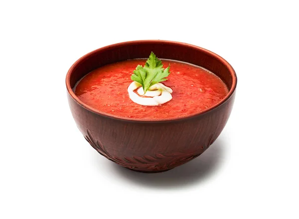 Zuppa di pomodoro con prezzemolo e crema di latte in una ciotola marrone isolata su sfondo bianco — Foto Stock