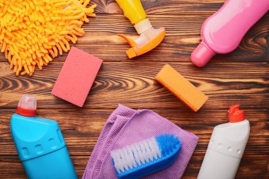 Ahşap bir arka planda yıkama ve temizleme araçlarının üst görünümü.
