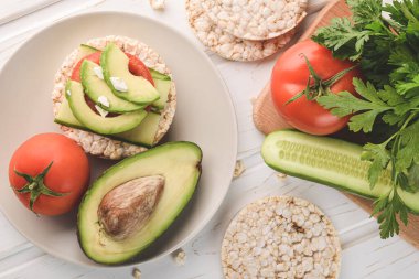 Manzaralı sağlıklı pirinç keki avokado ve salatalıklı domates..