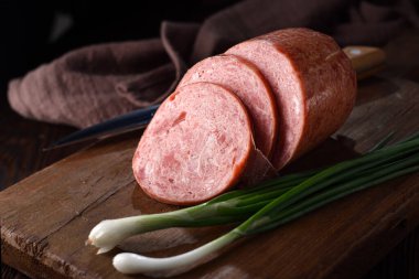 Kesme tahtasında dilimlenmiş jambon..