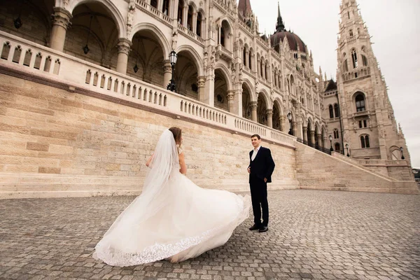 Жених и невеста обнимаются на старой городской улице. Свадебная пара прогулки в Будапеште возле здания парламента . — стоковое фото
