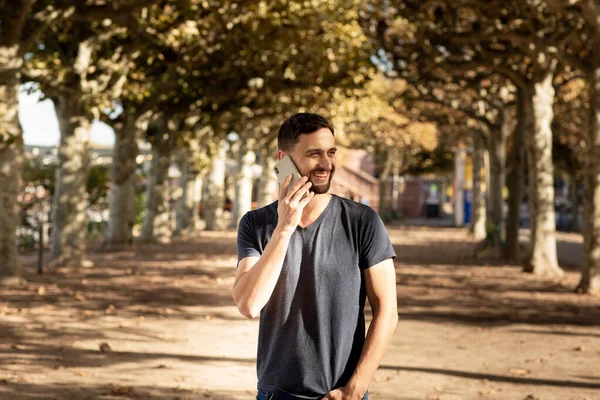 Jovem Tshirt Rua Fala Telefone Celular Sorri Fundo Uma Pista — Fotografia de Stock