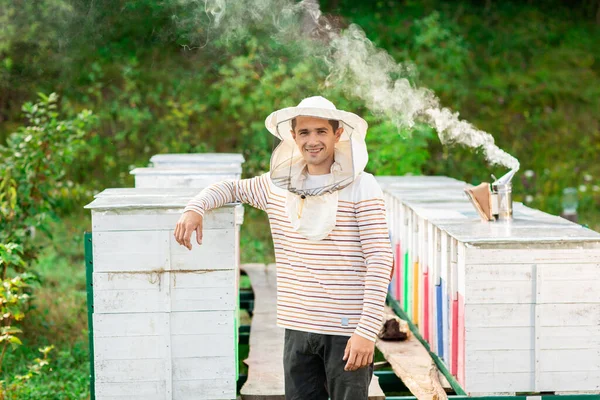 Včelař Ochranném Víčku Stojí Mezi Úly Kovovém Rámu Pokrytém Prkny — Stock fotografie