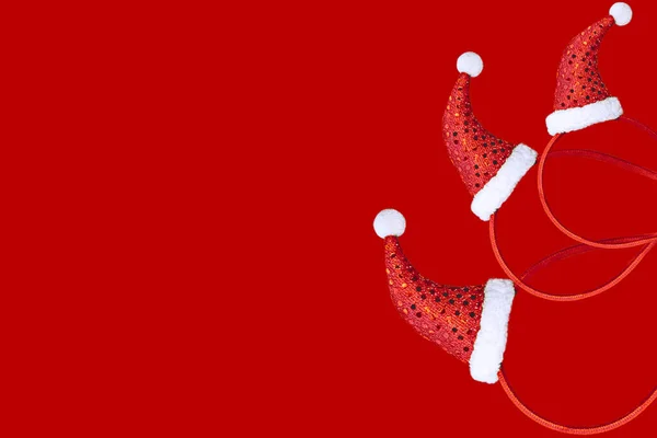 Χριστουγεννιάτικη διακόσμηση με τη μορφή ενός μοτίβου με ένα κόκκινο καπάκι σε ένα κόκκινο φόντο με ανοιχτό χώρο. Πρότυπο επίπεδου κείσου. — Φωτογραφία Αρχείου