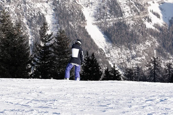 Snowboardåkare Lila Byxor Med Hastighet Nerför Slänten Mot Bergens Bakgrund — Stockfoto