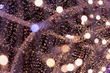 Yanıp sönen ışıklardan oluşan bir çelenk ve güzel bir bokeh ile ahşap bir yapı. Odaklanmış Arkaplan. Tatil kavramı