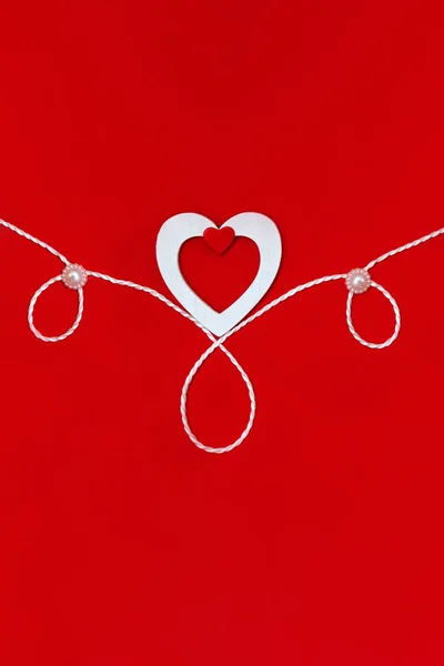 Top view of a composition for Valentine's Day on a red background with white and red hearts and a white rope. Holiday concept, greeting card, background. — 스톡 사진