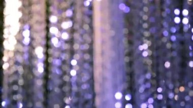 Bokeh beyazı, pembe ve mor şeklinde yanıp sönen ışıklardan oluşan bir çelenk ışığı. Tatil, Noel, aydınlanma, parti konsepti.