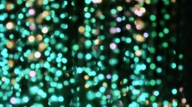 Bokeh beyazı, turkuaz, kırmızı, sarı ve mor şeklinde yanıp sönen ışıklardan oluşan bir çelenk. Tatil, Noel, aydınlanma, parti konsepti.