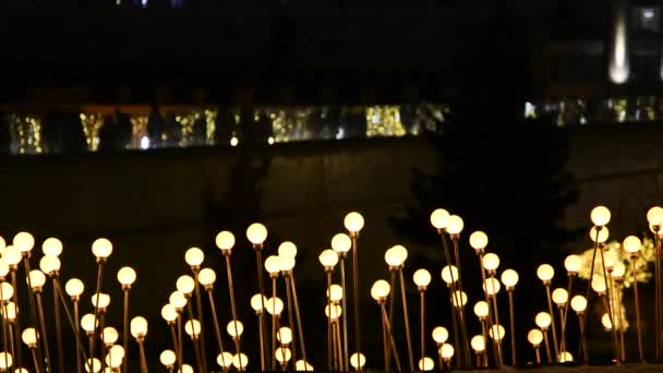 Une composition légère d'un grand nombre de lanternes rondes dans la ville qui changent de couleur en douceur et les gens marchent en arrière-plan. Concept vacances, Noël, illumination, ville . — Video