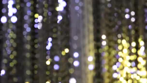 Light illumination from a garland of flashing lights in the form of bokeh of white, purple and gold. The concept of a holiday, Christmas, illumination, party. — Stock Video