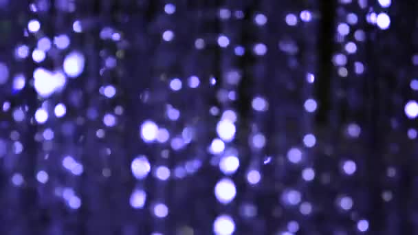 Iluminação de luz de uma grinalda de luzes piscando na forma de bokeh branco, turquesa, vermelho e roxo. O conceito de um feriado, Natal, iluminação, festa . — Vídeo de Stock