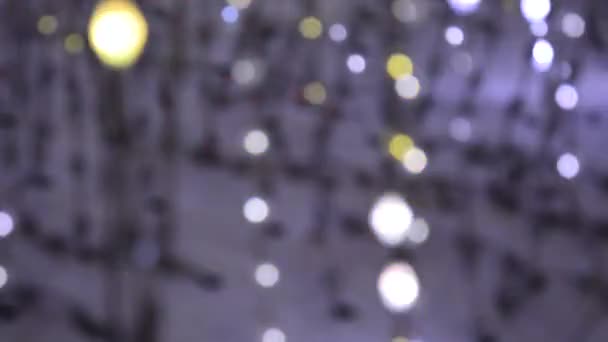 Iluminación de luz de una guirnalda de luces intermitentes en forma de bokeh de blanco, púrpura, rosa y oro. El concepto de unas vacaciones, Navidad, iluminación, fiesta . — Vídeos de Stock
