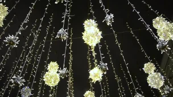 Iluminación de la calle Navidad en Moscú en la calle Nikolskaya. ciudad está decorada para las vacaciones con bolas luminosas suspendidas en las cuerdas y balanceándose en el viento sobre un fondo de bokeh parpadeante — Vídeo de stock