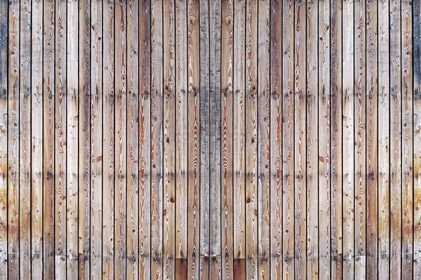 A solid wall of aged brown wooden planks with clogged nails located vertically. Concept for texture, background, interior